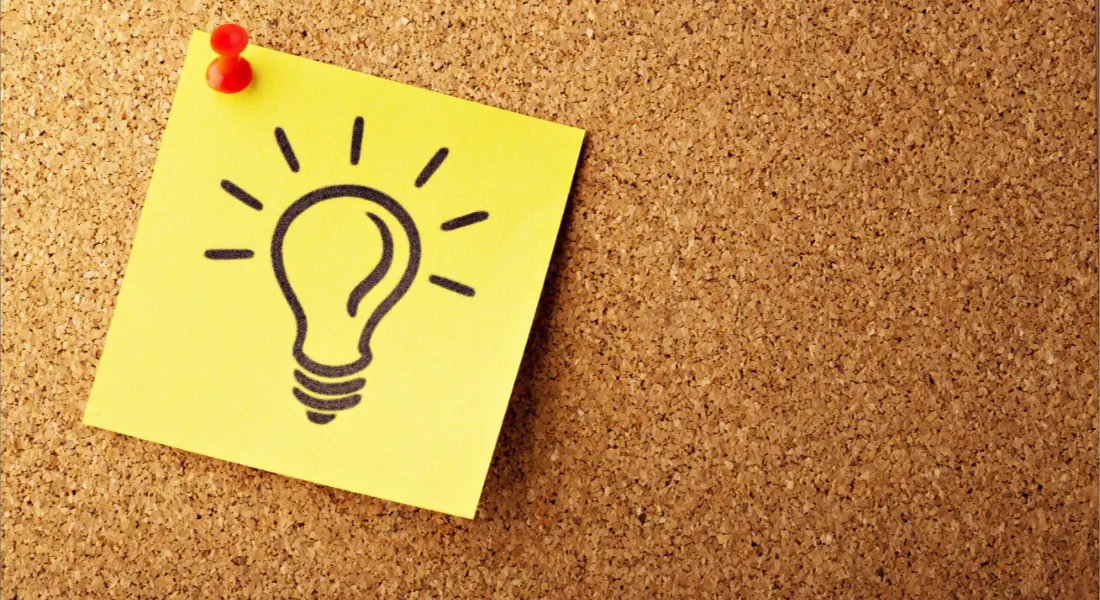 Light bulb idea note on a cork board